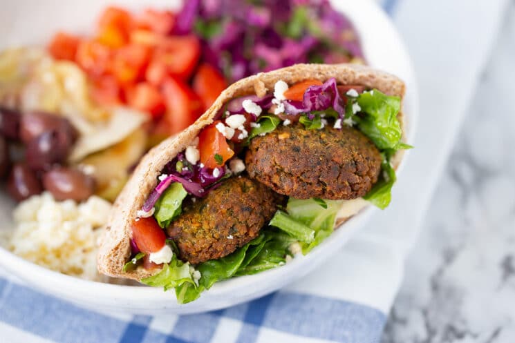 falafel served in a pita stuffed with veggies served in a bowl