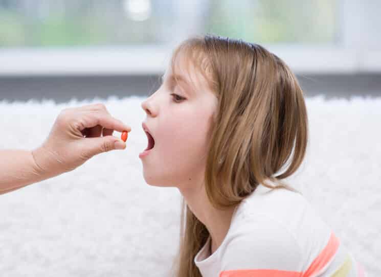 girl taking probiotic pill