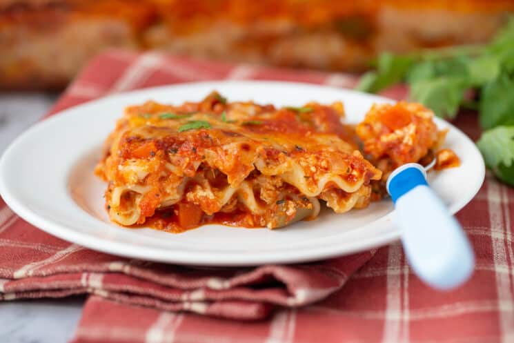 kids' plate of lasagna with a blue fork
