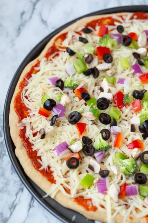 unbaked pizza filled with fresh toppings