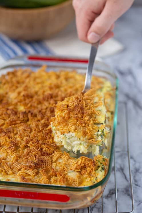 zucchini casserole with crushed cereal topping in a glass serving dish