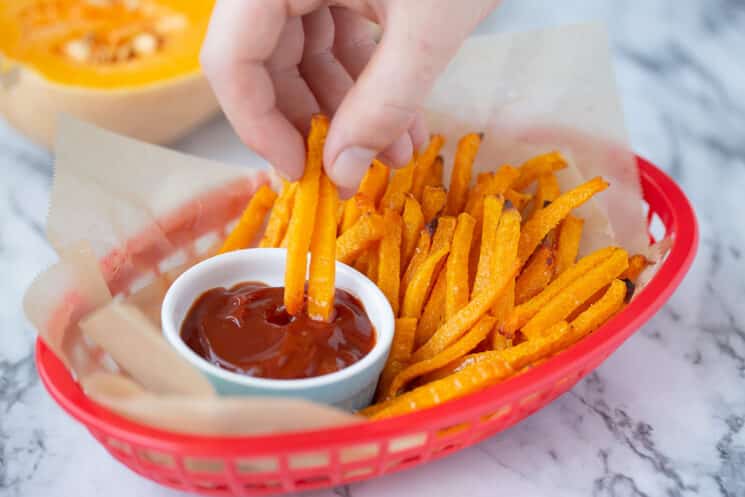 patatas fritas de calabaza que se sumergen en salsa de tomate