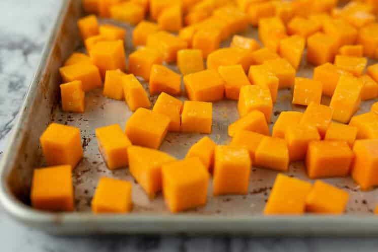 baking sheet with raw butternut squash cubes ready to go in the oven