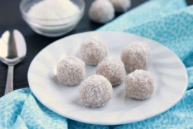 ball shaped treats rolled in coconut on a plate with a blue napkin 