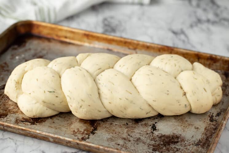 loaf of unbaked braided bread, raw dough on a baking sheet ready for the oven