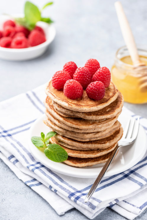 Stack of pancakes topped with raspberries