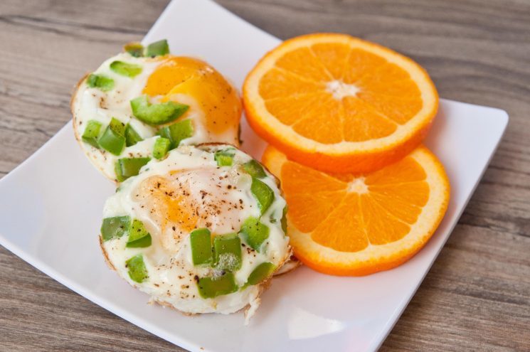 baked egg cups with peppers and orange slices on the side