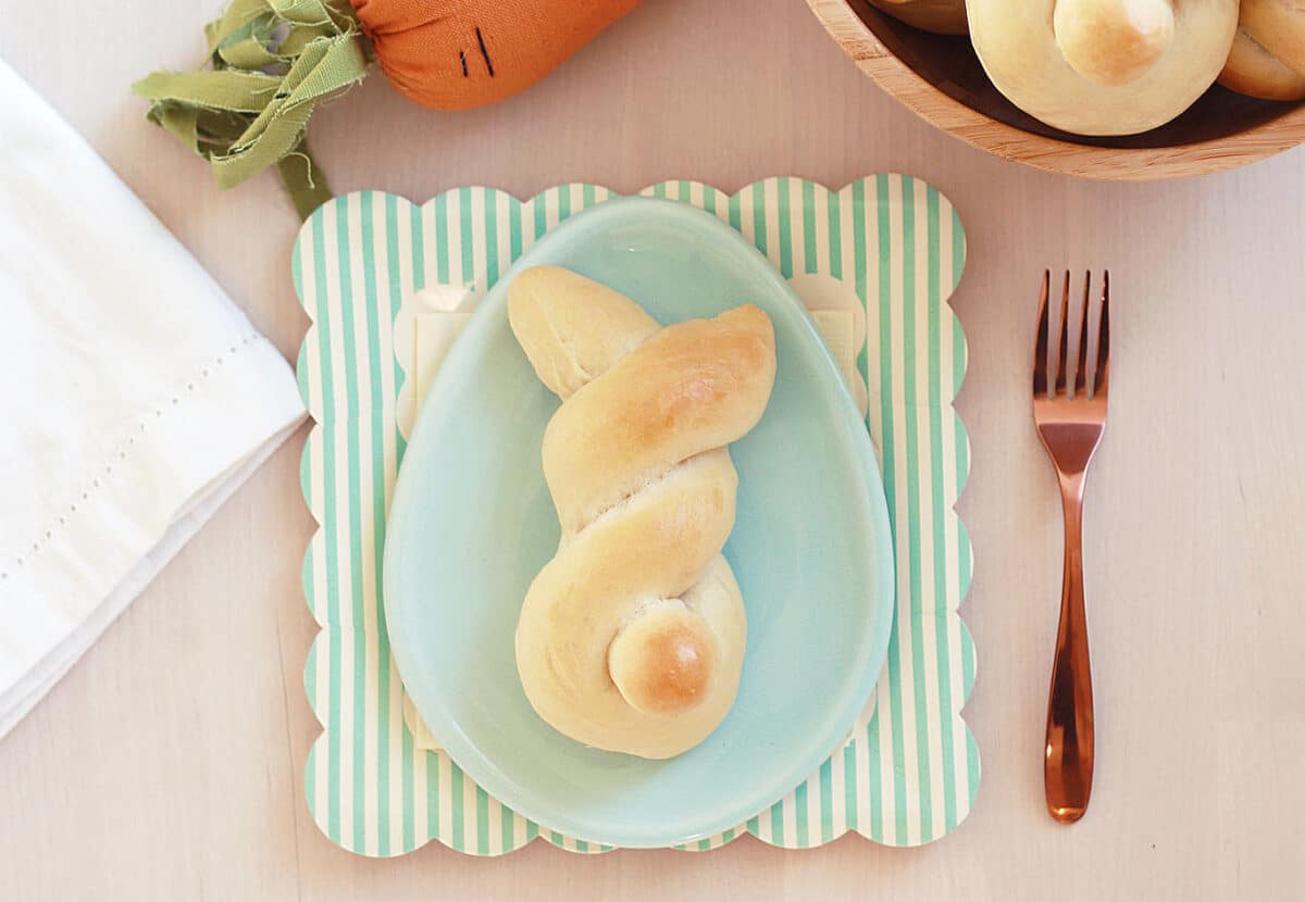 bread shaped like a bunny on an egg shaped blue plate