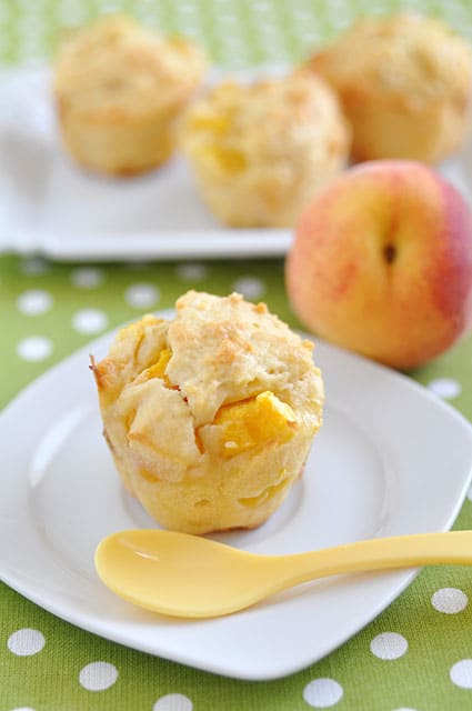 healthy cinnamon peach muffin with peaches in the background