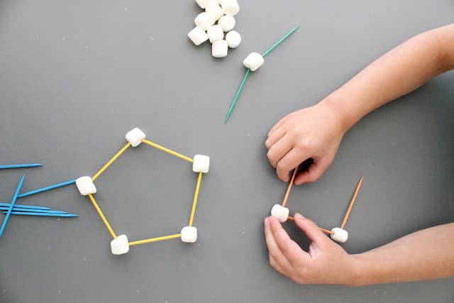 toddler building sculptures with toothpicks and marshmallows