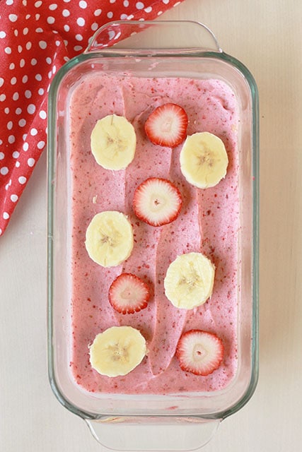strawberry banana sorbet in a rectangle dish with strawberry and banana slices on top