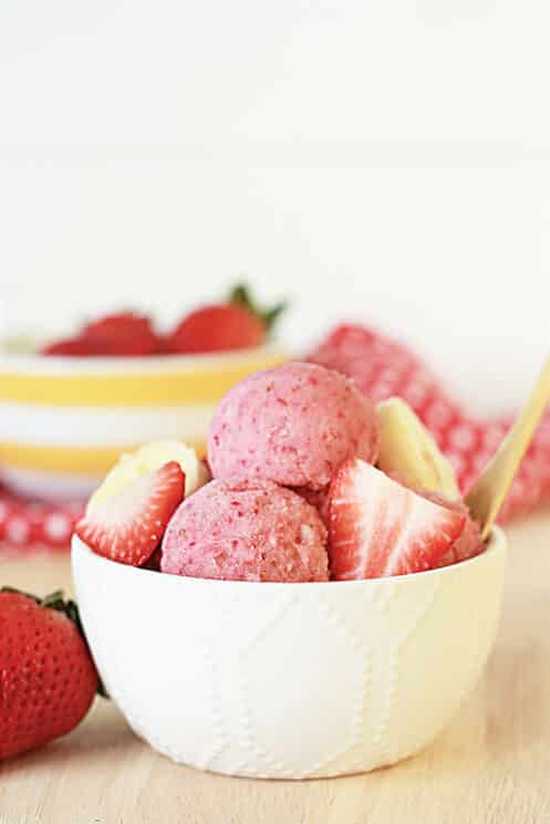 strawberry banana sorbet in a white bowl with strawberry and banana slices