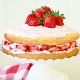 Vertical image of low sugar vanilla cake with homemade strawberry frosting