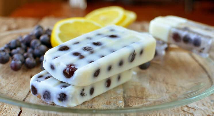 Blueberry Lemon Pudding pops on a plate with blueberries and lemons