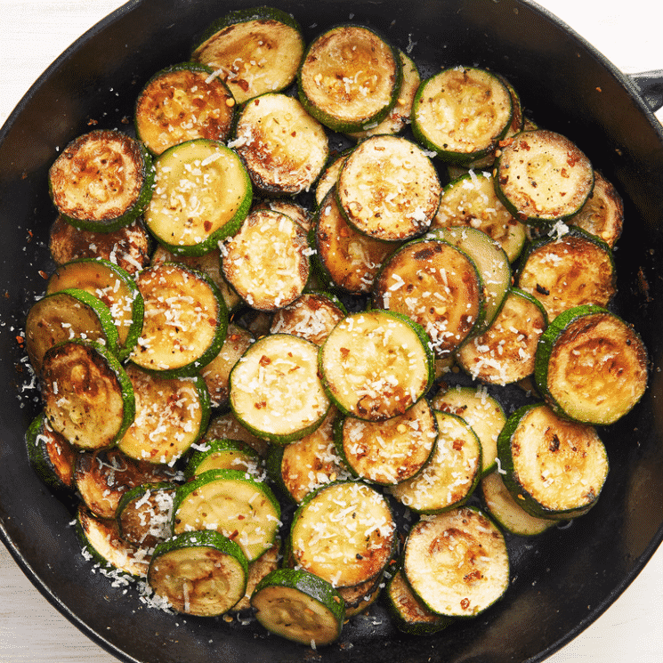 zucchini saute in a cast iron skillet with parmesan cheese