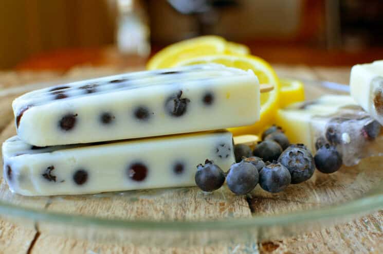 Blueberry Lemon Pudding pops on a plate with blueberries and lemons