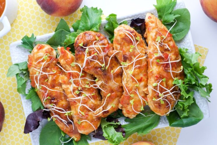 grilled peach chicken tenders on a bed of lettuce