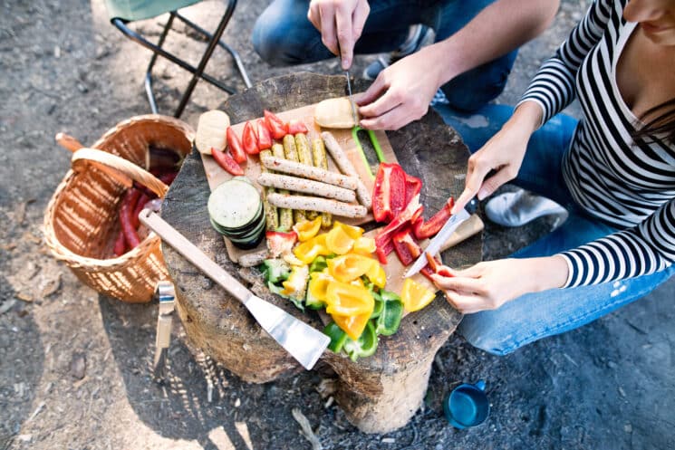 couple chopping bell peppers at a campsite