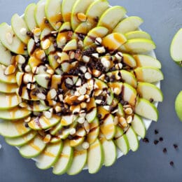 Apple nachos with white and dark chocolate chips, caramel syrup and almonds