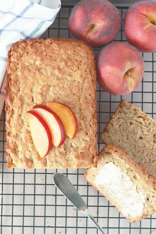 Sliced peach crisp bread with 3 peaches in the background