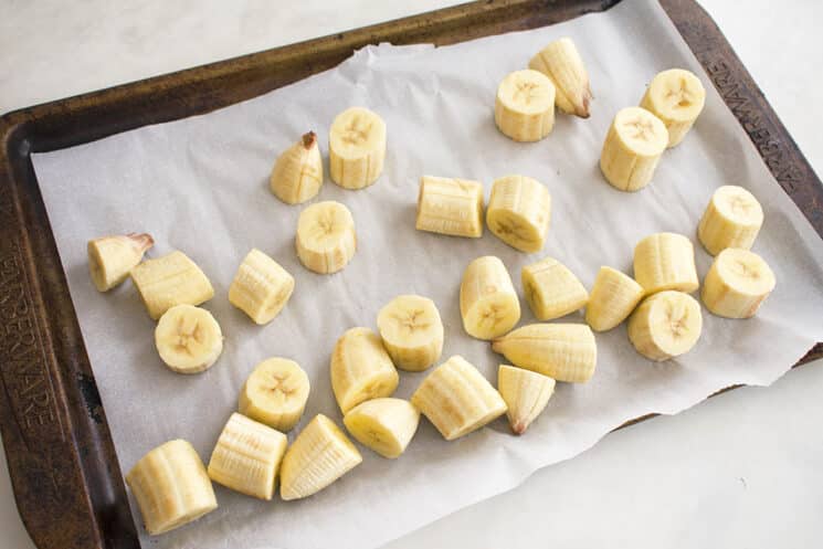 frozen banana pieces on a tray with parchment paper