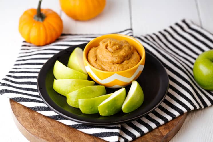 pumpkin spice dip with green apples surrounding the bowl of dip