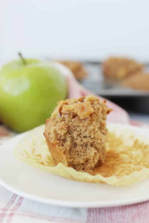 close up of a whole wheat applesauce muffin broken in half on a plate