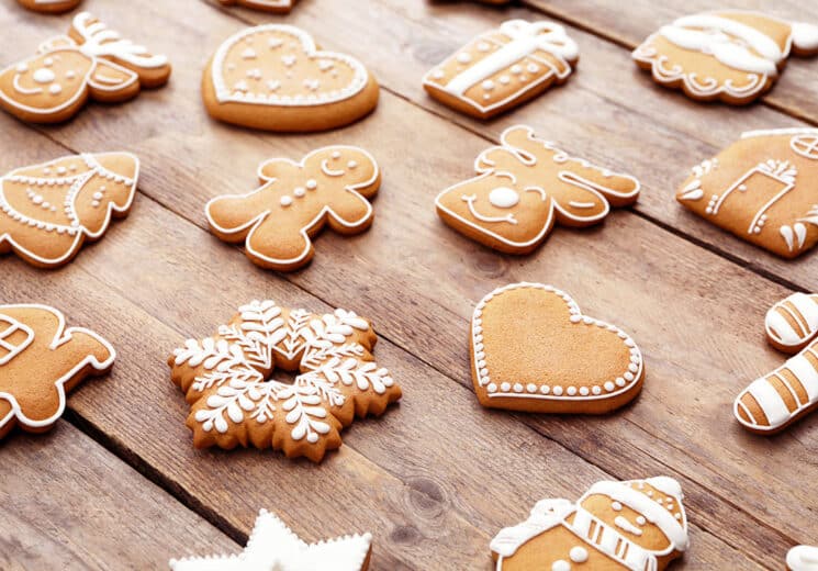 Different shapes of homemade gingerbread cookies on a wood table