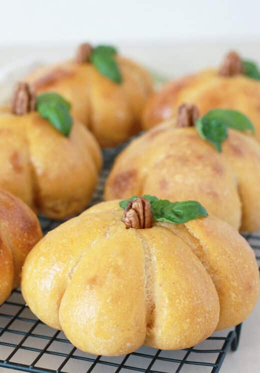 sourdough pumpkin bread bowl close up of a golden brown orange bread bowl with a pecan for a stem and basil for leaves