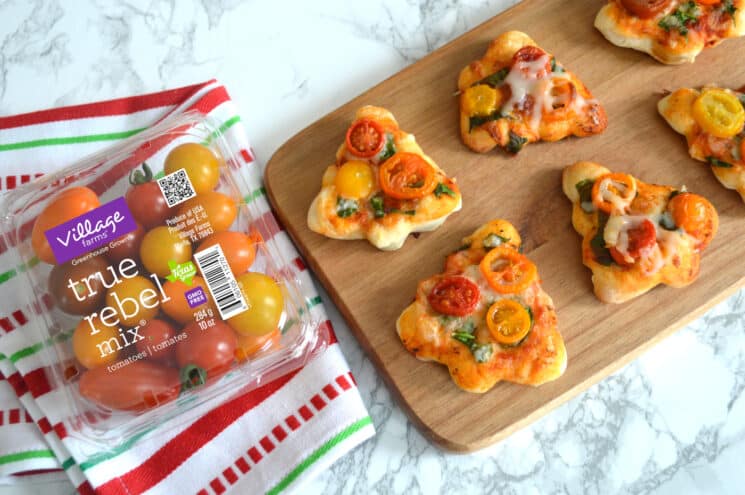 mini pizzas shaped like trees on a wooden cutting board