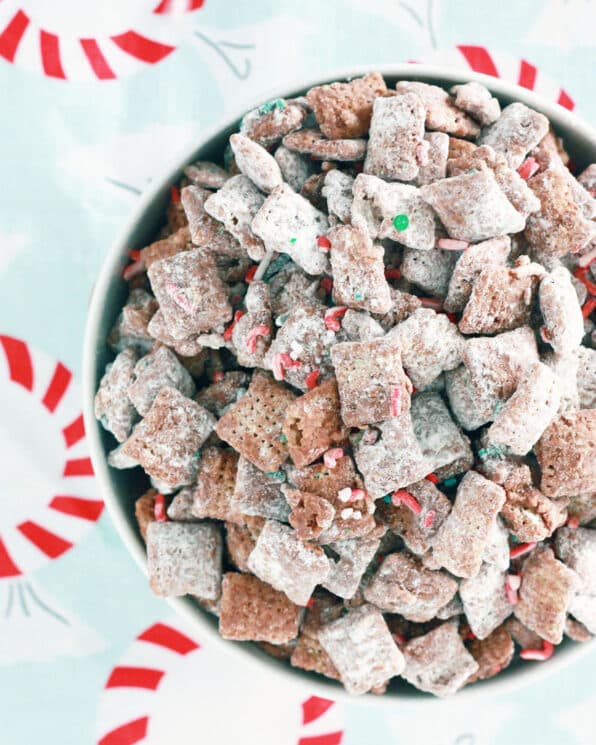 cereal coated in a chocolate, powdered sugar and holiday sprinkles in a white bowl