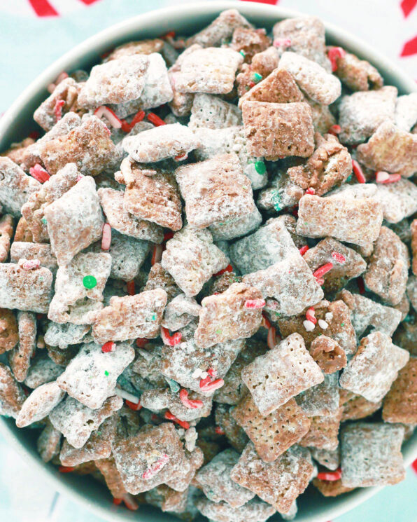 cereal coated in a chocolate, powdered sugar and holiday sprinkles in a white bowl