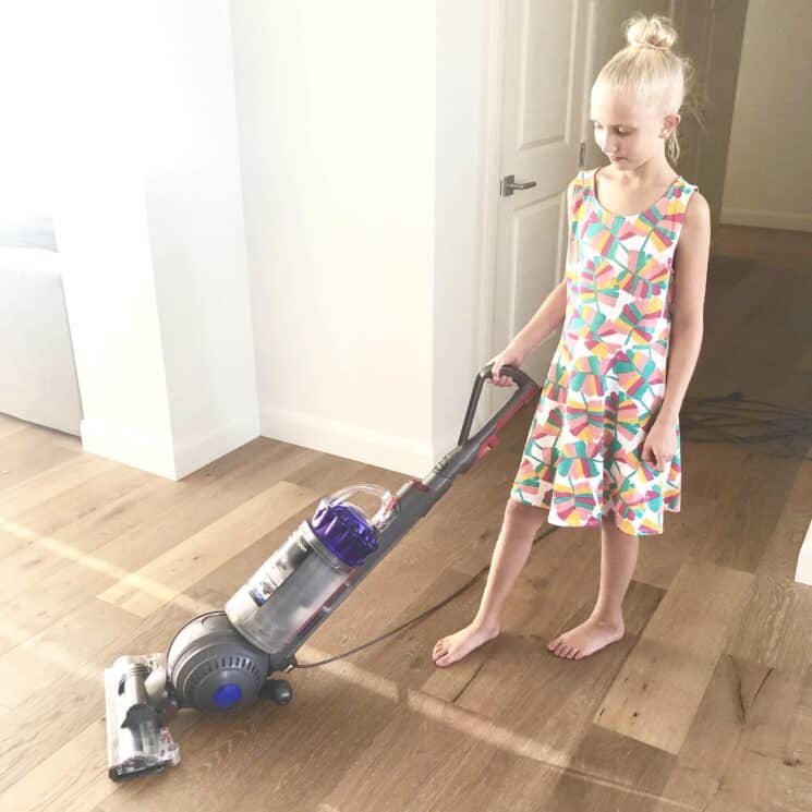 A young girl vacuuming