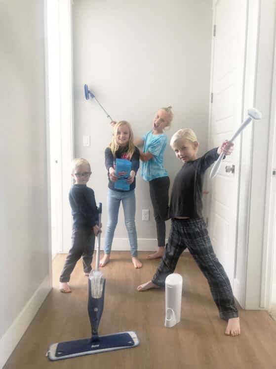 a group of young kids holding cleaning appliances