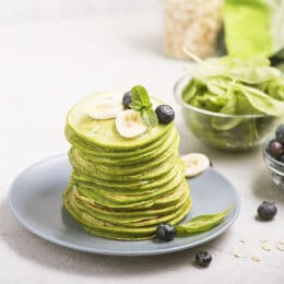 Green pancakes with spinach and blueberries, healthy snack, vegetarian food