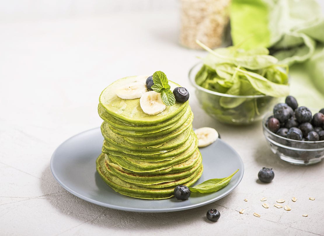 Green pancakes with spinach and blueberries, healthy snack, vegetarian food