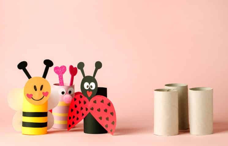 Paper toy insect for valentine romance baby shower, birthday party. Easy crafts for kids on pink background, copy space, die creative idea from toilet tube roll, recycle reuse eco