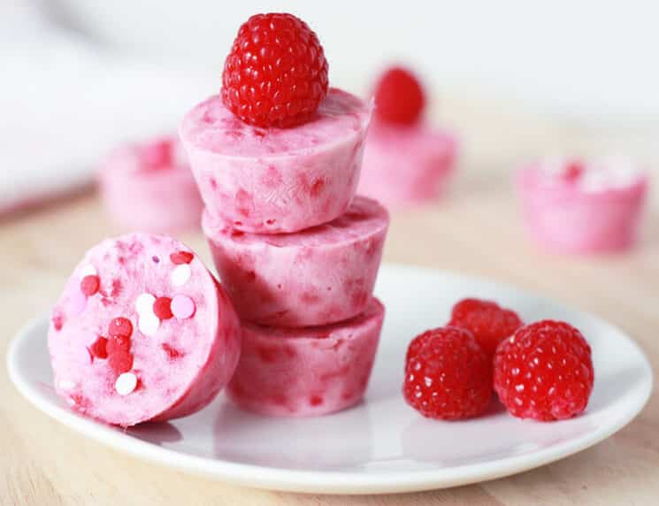 raspberry frozen yogurt bites topped with colorful sprinkles and fresh raspberries