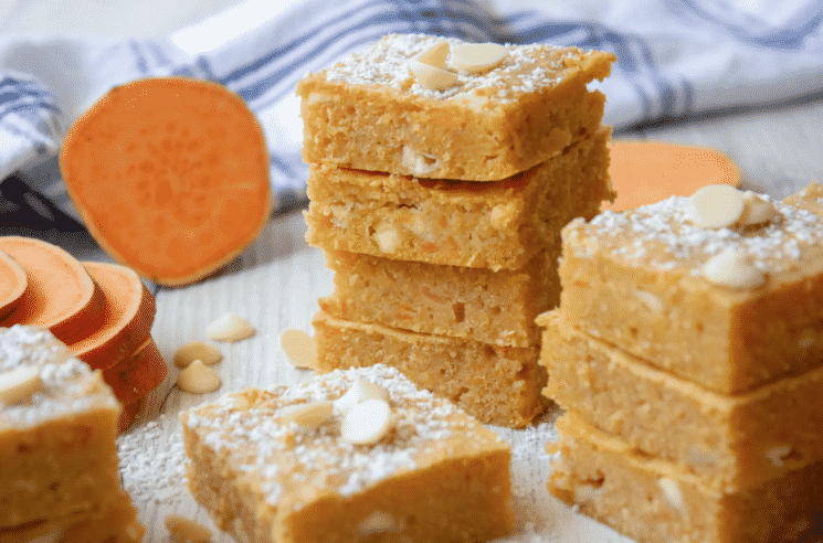 sweet potato blondies with white chocolate chips with a blue checkered towel in the background