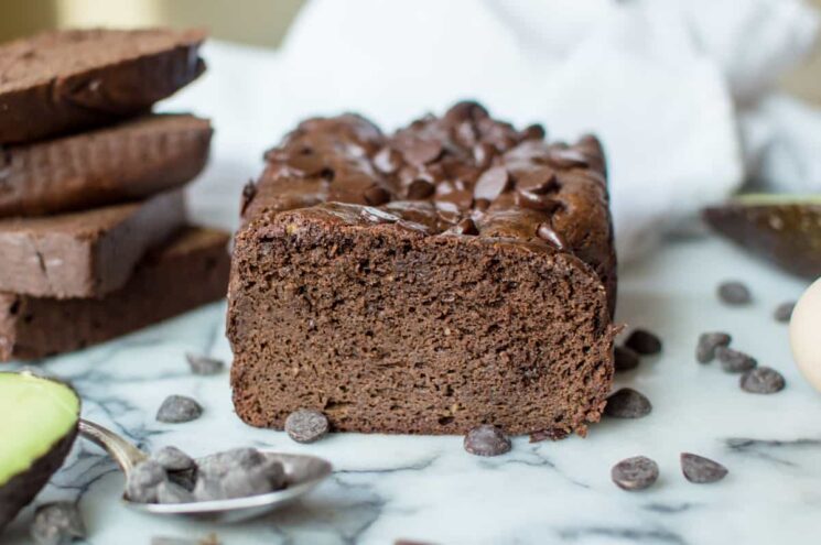 loaf of chocolate bread on a marble slab with scattered chocolate chips