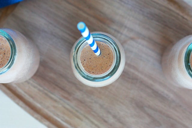 overhead view of chocolate milk in a milk bottle with a blue and white striped straw