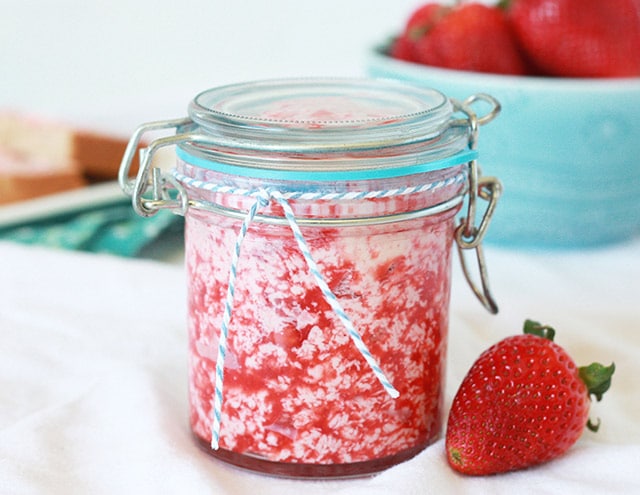 fresh strawberry butter in a glass with a blue and white striped ribbon