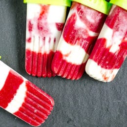 overhead view of strawberry creamsicles on a dark background