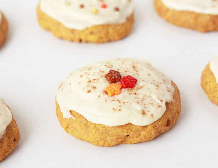 soft pumpkin cookie with maple frosting and fall sprinkles