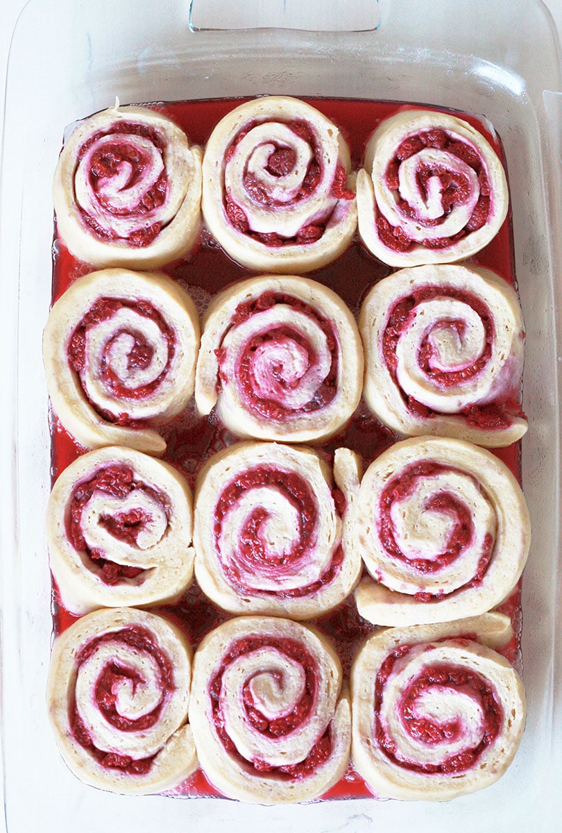 unbaked raspberry rolls in a baking dish