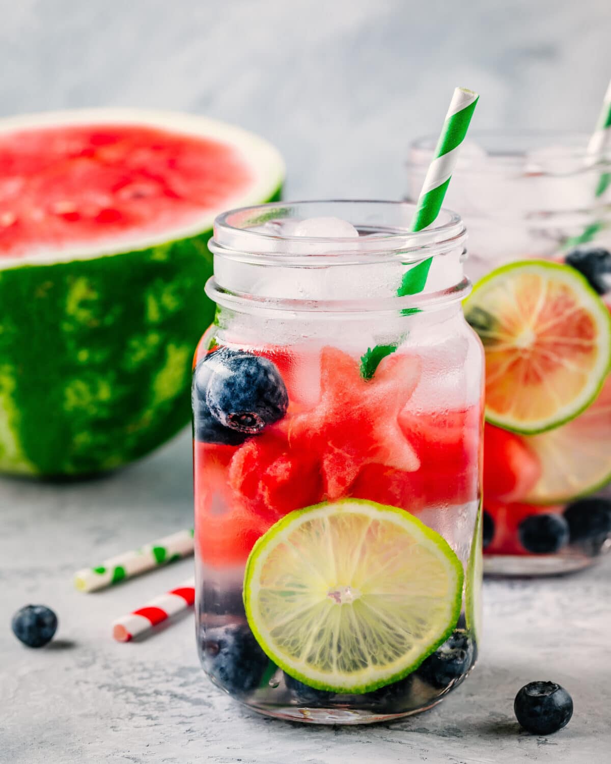 Fruit Infused water with watermelon, lime and blueberry. Ice cold summer drink in glass mason jar