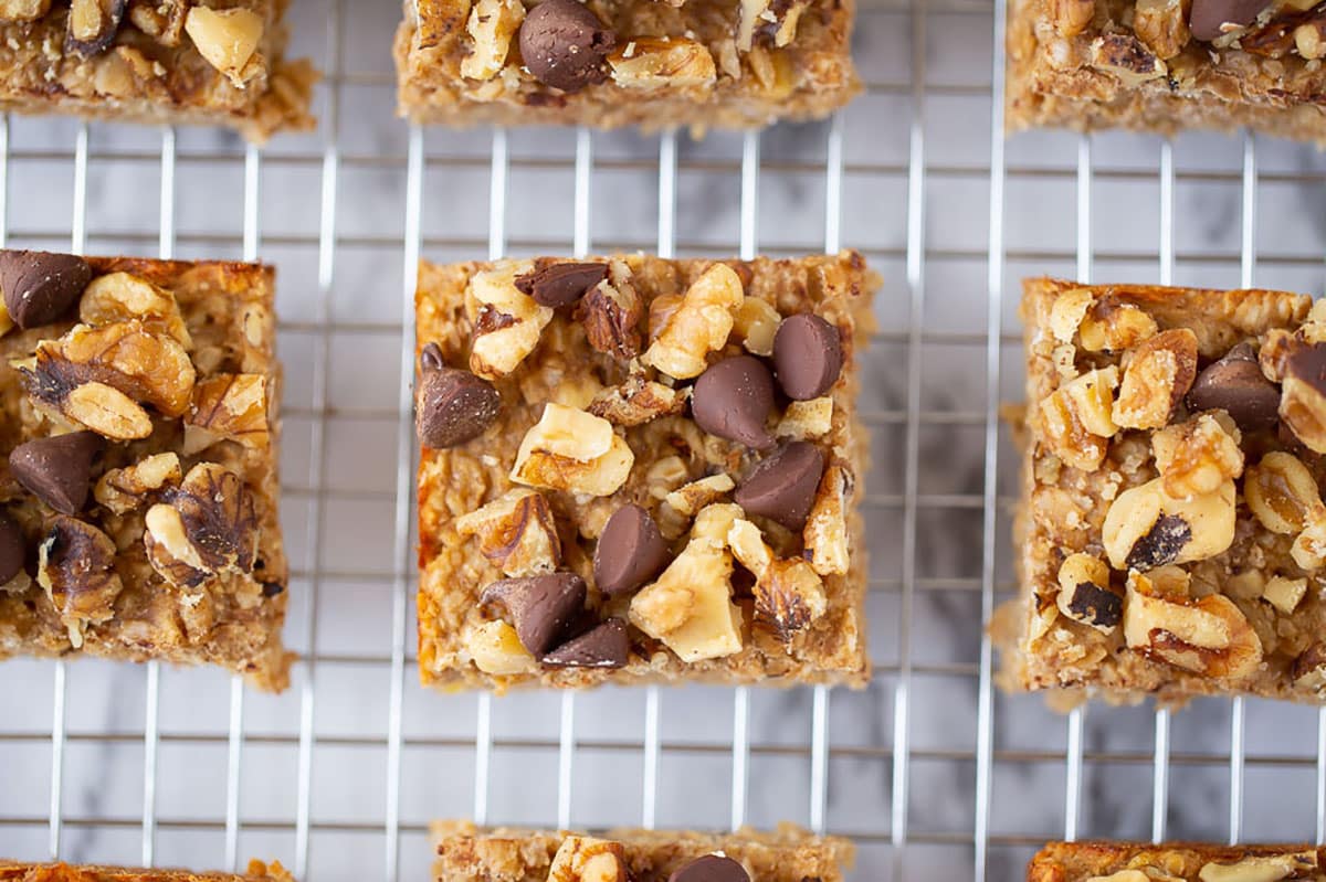 Three ingredient peanut butter banana snack bars on a cooling rack cut into squares.