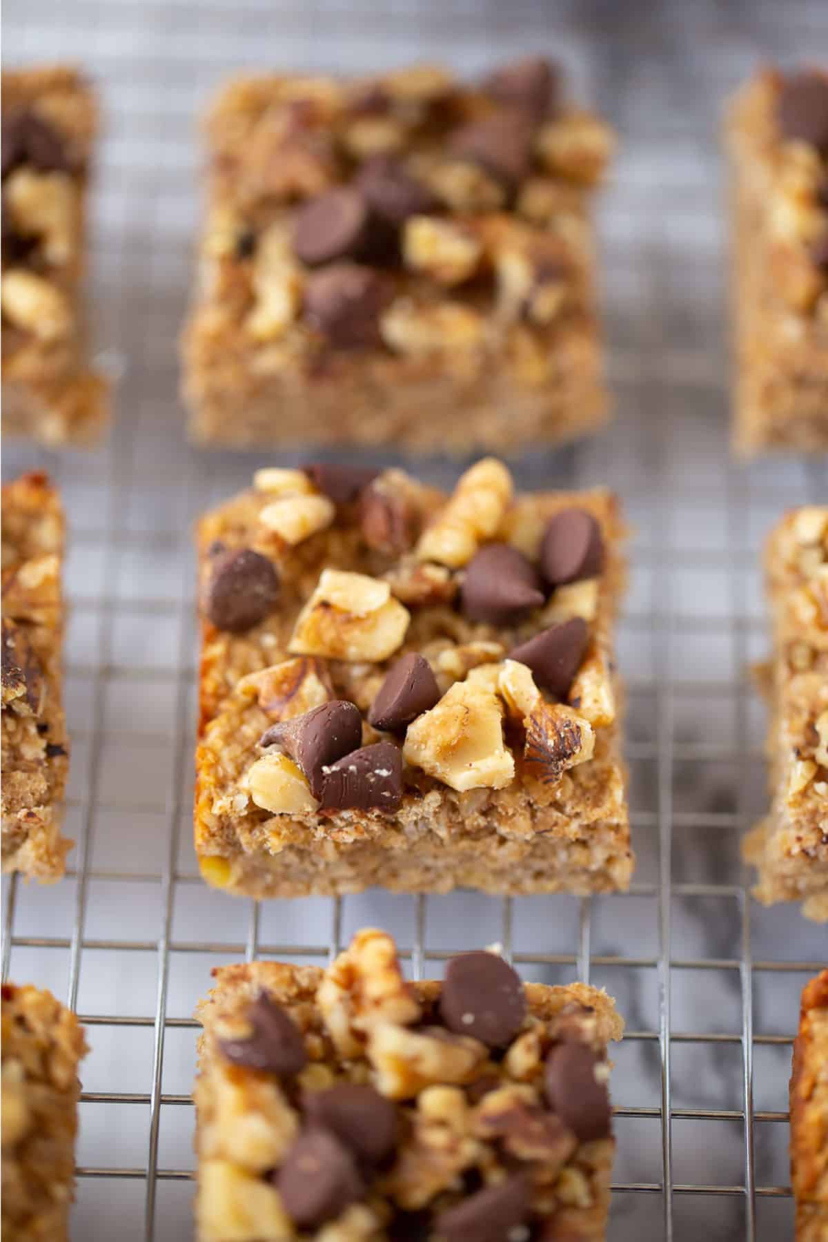 Three ingredient peanut butter banana snack bars on a cooling rack cut into squares.