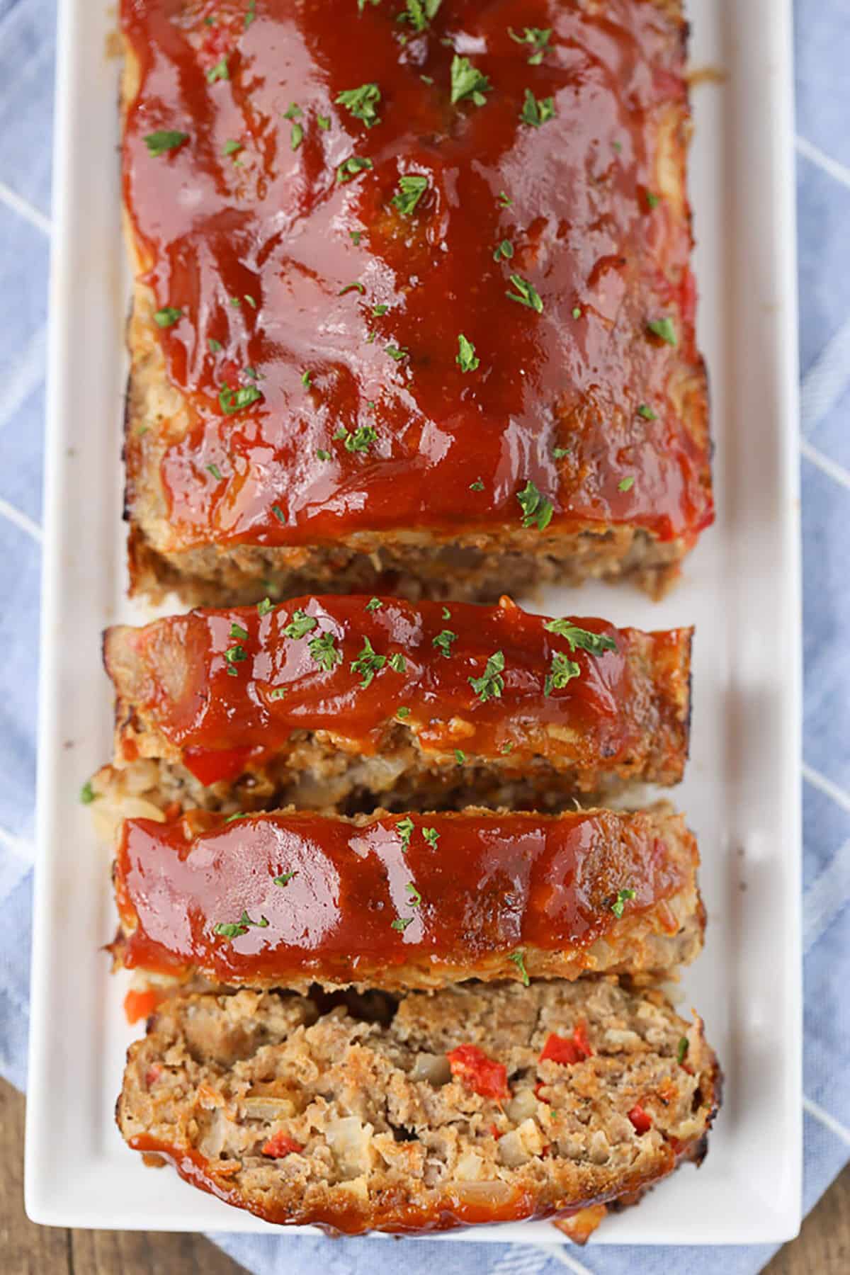 healthy turkey meatloaf with slices from an aerial view on a white serving platter