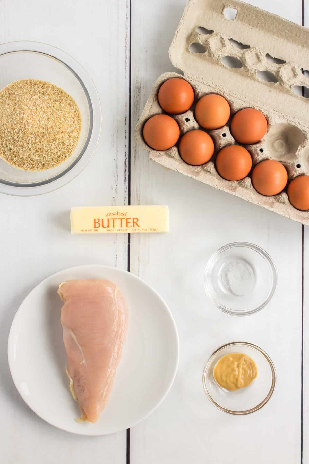 ingredients for kid-friendly homemade chicken nuggets: chicken breast, breadcrumbs, butter, salt, eggs, and honey mustard for dipping sauce